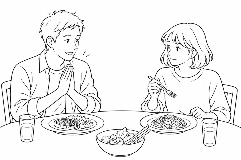 食前に手を合わせる友人を、フォークを持って見守る人